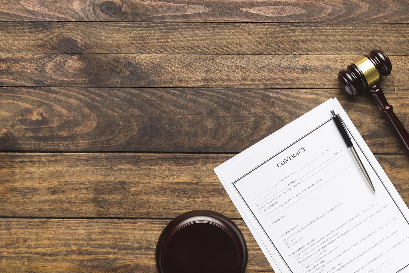 Contrat sur une table en bois - Image designed by Freepik.com